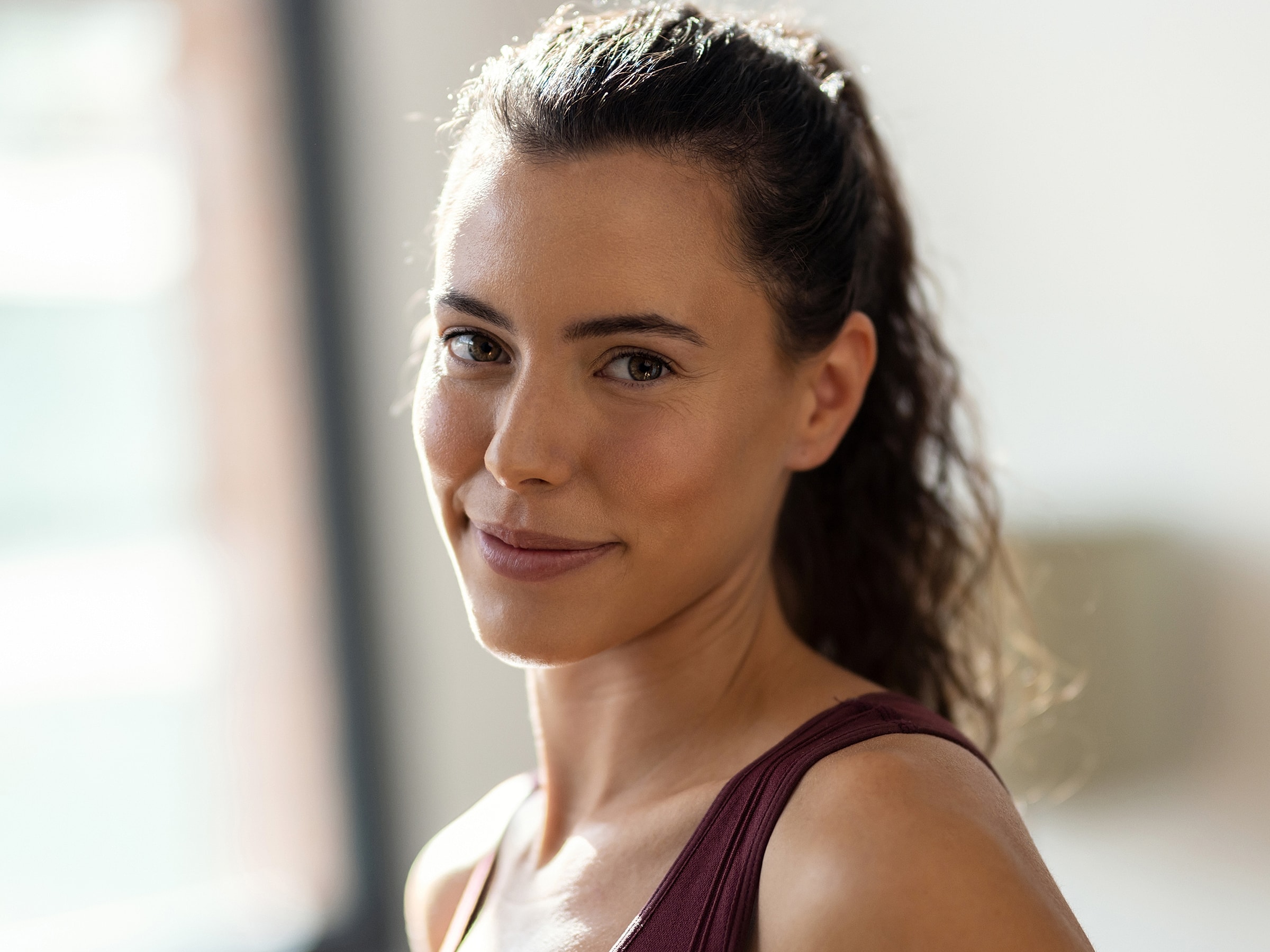 Smiling woman with curly hair and athletic attire.